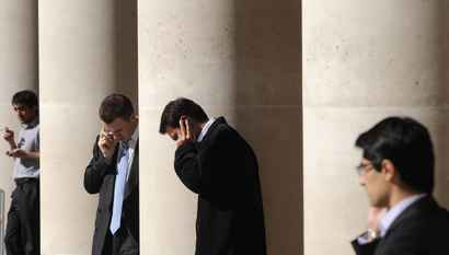 City workers make phone calls outside the London Stock Exchange in Paternoster Square in the City of London at lunchtime October 1, 2008. European policymakers have called on the U.S. Senate to approve a revised rescue plan aimed at tackling the worst financial crisis since the 1930s. REUTERS/Toby Melville