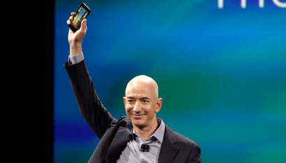 Amazon CEO Jeff Bezos shows off his company's new smartphone, the Fire Phone, at a news conference in Seattle, Washington June 18, 2014. REUTERS/Jason Redmond (UNITED STATES - Tags: SCIENCE TECHNOLOGY BUSINESS TPX IMAGES OF THE DAY) - RTR3UI04