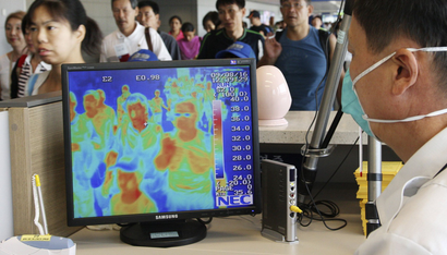 A South Korean quarantine officer checks a thermal camera monitoring the body temperature of passengers arriving from overseas against the possible infection of swine flu at Incheon International Airport in Incheon, west of Seoul, South Korea, Sunday, Aug. 16, 2009. South Korea says a woman infected with swine flu has died, becoming the country's second fatality linked to the virus.(AP Photo/Yonhap, Ahn Jung-hwan