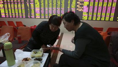 DATE IMPORTED:Investors look at a mobile phone as they have lunch in front of an electronic board showing stock information at a brokerage house in Shenyang, Liaoning province February 5, 2015. China stocks surrendered early gains on Thursday as traders took profits after the central bank unveiled its latest stimulus measures. REUTERS/Stringer (CHINA - Tags: BUSINESS) CHINA OUT. NO COMMERCIAL OR EDITORIAL SALES IN CHINA