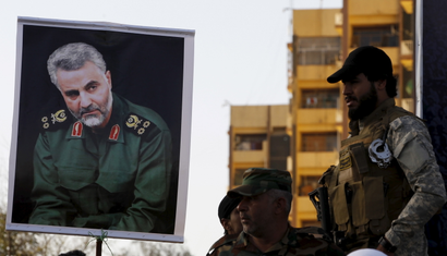 Soldiers hold a portrait of powerful Iranian commander Qassem Suleimani.