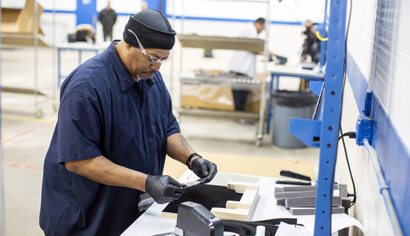 Operators and assemblers assemble medical face shields at Ford Motor Company