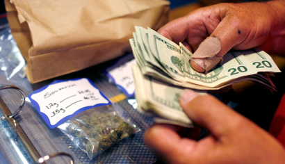 A customer makes a medical marijuana purchase at the Coffeeshop Blue Sky dispensary in Oakland, California June 30, 2010. California, the U.S. state that first allowed sales of medicinal marijuana in 1996, may take away all restrictions on adult use of the drug in a November vote, giving local governments the option to regulate sales and growing of marijuana. Picture taken June 30, 2010.
