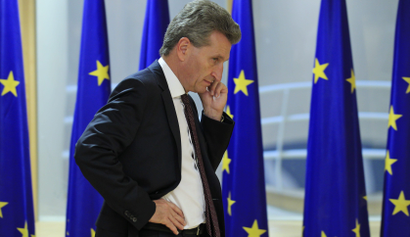 European Energy Commissioner Oettinger talks on his cell phone ahead of a meeting of the European Commission and an Irish ministers delegation in Brussels