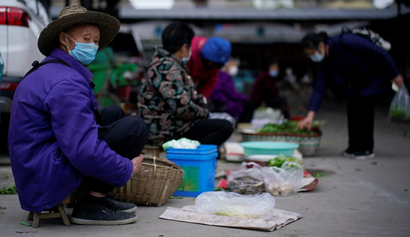 Street vendors wearing face masks wait for customers at their vegetable stalls in Jingzhou, after the lockdown was eased in Hubei province, the epicentre of China's coronavirus disease (COVID-19) outbreak, March 27, 2020.