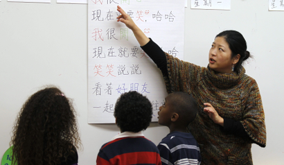 Teacher Kennis Wong (R) points to Chinese characters on a board at Broadway Elementary School in Venice, Los Angeles, California, April 11, 2011. The school launched one of only two English-Mandarin Chinese dual-language immersion programs in the Los Angeles Unified School District in September 2010.