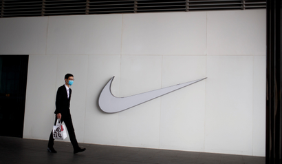 A man wearing a face mask passes a Nike store, as the country is hit by the novel coronavirus outbreak, in Beijing