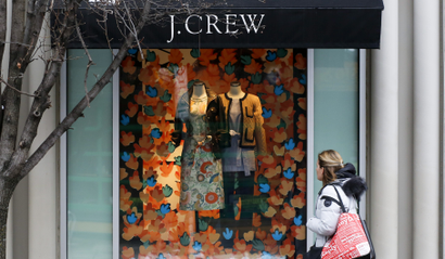 A shopper passes the display in the window of a J.Crew store in the Shadyside shopping district of Pittsburgh Friday, Feb. 10, 2017. (AP Photo/Gene J. Puskar)