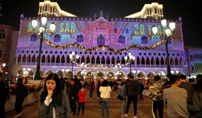 People enjoy a light show on the building of Venetian Macao casino in Macau, China