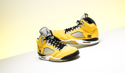 A pair of yellow Nike Air Jordan 5s