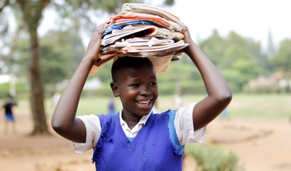 A student carries books at the Senator Obama primary school near ancestral home of U.S. President Barack Obama in Nyangoma village in Kogelo, west of Kenya's capital Nairobi, June 23, 2015. When Barack Obama visits Africa this month, he will be welcomed by a continent that had expected closer attention from a man they claim as their son, a sentiment felt acutely in the Kenyan village where the 44th U.S. president's father is buried. Picture taken June 23, 2015.