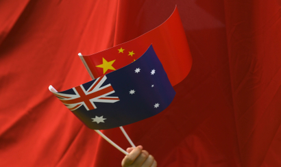 A supporter waves Chinese and Australian national flags during the arrival of Chinese Premier Li Keqiang to the Parliament House in Canberra, Australia, 23 March 2017. Li Keqiang is on a five-day official visit to Australia.