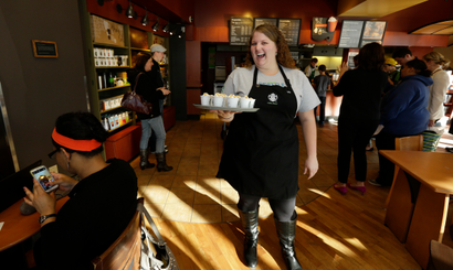Starbucks barista Liz West carries a tray of samples as she works in a Starbucks store, Wednesday, Oct. 23, 2013, in Seattle. (AP Photo/Ted S. Warren)