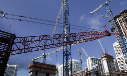 This Thursday, July 24, 2014 photo shows construction cranes at the Brickell City Centre project in downtown Miami. According to real estate license applications in 2013, the number of U.S. real estate agents is increasing as the housing market recovers from the Great Recession.