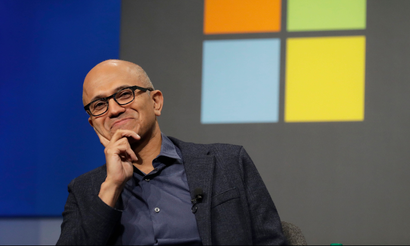 FILE- In this Wednesday, Nov. 28, 2018, file photo Microsoft CEO Satya Nadella listens to a question as he sits in front of the Windows logo during the annual Microsoft Corp. shareholders meeting in Bellevue, Wash. Microsoft on Friday, Nov. 30, surpassed Apple as the world's most valuable publicly traded company. Under Nadella Microsoft has found stability by moving away from its flagship Windows operating system and focusing on cloud-computing services with long-term business contracts. (AP Photo/Ted S. Warren, File)