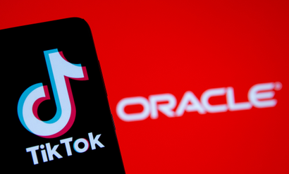 Smartphone with Tik Tok logo is seen in front of displayed Oracle logo in this illustration