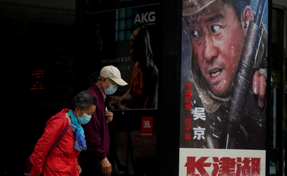 Chinese citizens walk past a poster of war epic the Battle at Lake Changjin.