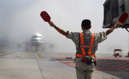 A plane carrying the first wave of mainland China tourists from the coastal city of Xiamen is sprayed with water from fire trucks in a salute as it lands at the Taipei Airport Friday, July 4, 2008, in Taipei, Taiwan. More than 200 mainland Chinese tourists arrived in Taiwan on Friday on the first regular commercial flight in nearly six decades, a historic move aimed at further easing tensions between the old foes. (AP Photo/Chiang Ying-ying