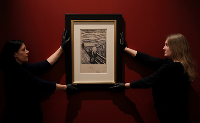 Staff-members pose for a photograph as they hang a lithograph of The Scream by Edvard Munch ahead of the exhibition "Edvard Munch: love and angst", soon to be on display at the British Museum in London, Britain, March 20, 2019.