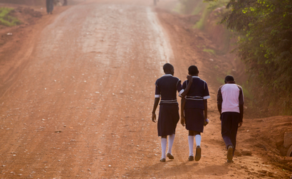 Ugandan children walk up a dusty murram road to school in the morning on the first day of the new term, in Kasangati, near Kampala, in Uganda Monday, Feb. 22, 2016. The new term started later than usual due to the recent presidential elections.