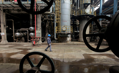  A worker walks past oil pipes at a refinery in Wuhan, China.