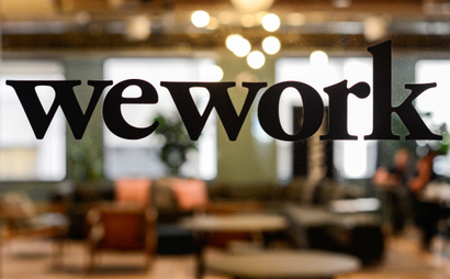 The WeWork logo on a glass office door.