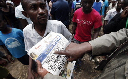 Supporters of Kenyan Prime Minister Raila Odinga look at a newspaper in the Mathare slum in the Kenyan capital of Nairobi March 9, 2013. Kenyan Prime Minister Raila Odinga will not concede this week's election and will launch a legal challenge if rival Uhuru Kenyatta is officially declared president, an adviser said on Saturday.