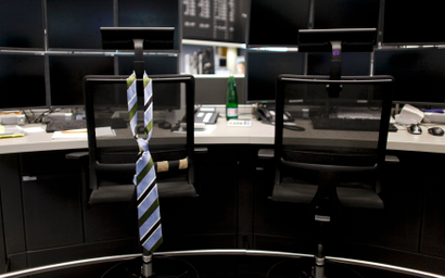 A tie hangs from an empty chair on a trader desk after the end of a trading day at the Frankfurt stock exchange
