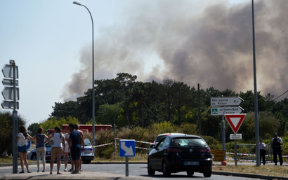 People observe a wildfire in France