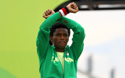 Ethiopia's Feyisa Lilesa crosses his wrists to protest Ethiopian government's crackdown on Oromo people.