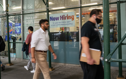 People walk past a Fedex "now hiring" sign in New York City.