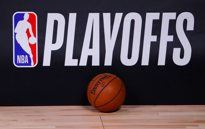 A basketball sits next to an NBA Playoffs logo