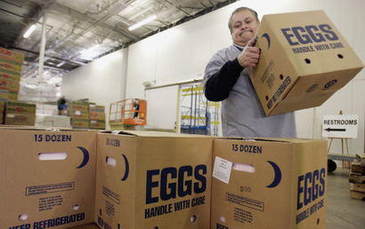 A worker at the North Texas Foodbank stacks boxes of eggs to be loaded into trucks and delivered to various soup kitchens and food distribution centers in Dallas, Texas November 20, 2006