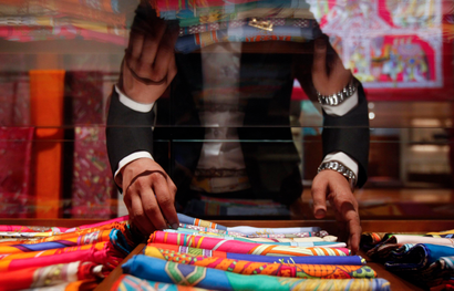 A saleswoman arranges scarves inside a Hermes showroom in Mumbai
