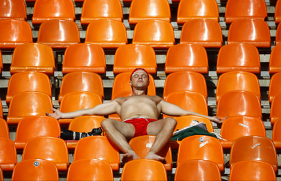 A spectator tans himself in the sun during the morning session of the IAAF World Athletics Championships at the Luzhniki stadium in Moscow August 13, 2013.