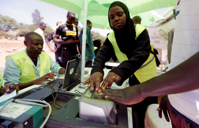 Officials from the Independent Electoral and Boundaries Commission (IEBC) records finger prints of a man as they collect data from the electorate during the launch of the 2017 general elections voter registration exercise within Kibera slums in Kenya's capital Nairobi, January 16, 2017.