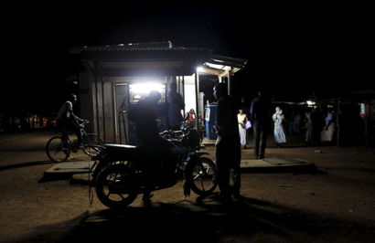 A motorcyclist fuels his bike at a station within the trading centre in the village of Kogelo, west of Kenya's capital, Nairobi. There are dimly lit shacks in the back.