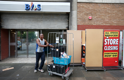 A worker removes items a BHS store. PwC received a record fine for its audits of the failed retailer