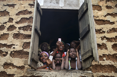 People gather at a window to watch a procession by followers of the Yoruba religion as part of a festival to celebrate the Osun river goddess in Osogbo, southwest Nigeria August 22, 2014.