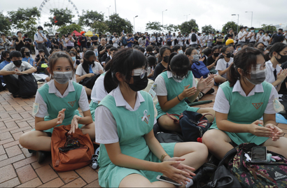 Uniformed high-school students sit on the ground during a protest at Admiralty in Hong Kong, on Monday, Sept. 2, 2019.