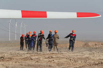 Workers install a wind turbine in Kazakhstan.