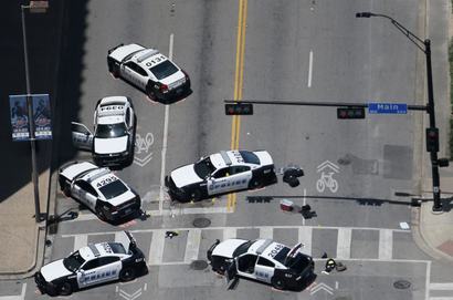 Police cars remain parked with the pavement marked by spray paint, in an aerial view of the crime scene of a shooting attack in downtown Dallas
