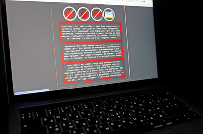 A laptop screen displays a warning message in Ukrainian, Russian and Polish, that appeared on the official website of the Ukrainian Foreign Ministry after a massive cyberattack in January 2022.