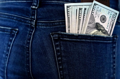 US currency is seen in a back pocket of blue jeans.