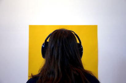 A museum visitor wearing noise-cancelling headphones.