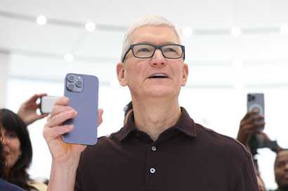 Apple CEO Tim Cook holds a new iPhone 14 Pro during an Apple special event.