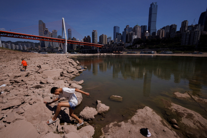 A person steps on rocks along the very shallow Yangtze River in Chongqing, China.