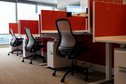 A row of empty cubicles with orange walls.