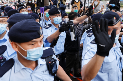 Police officers disperse supporters of pro-democracy activists outside a courthouse in Hong Kong.