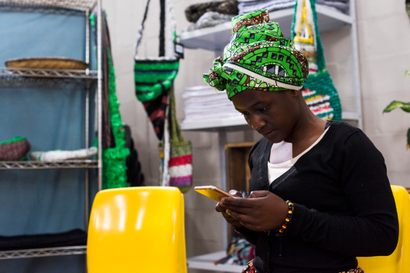 Photo of an African business woman using an iphone at work.